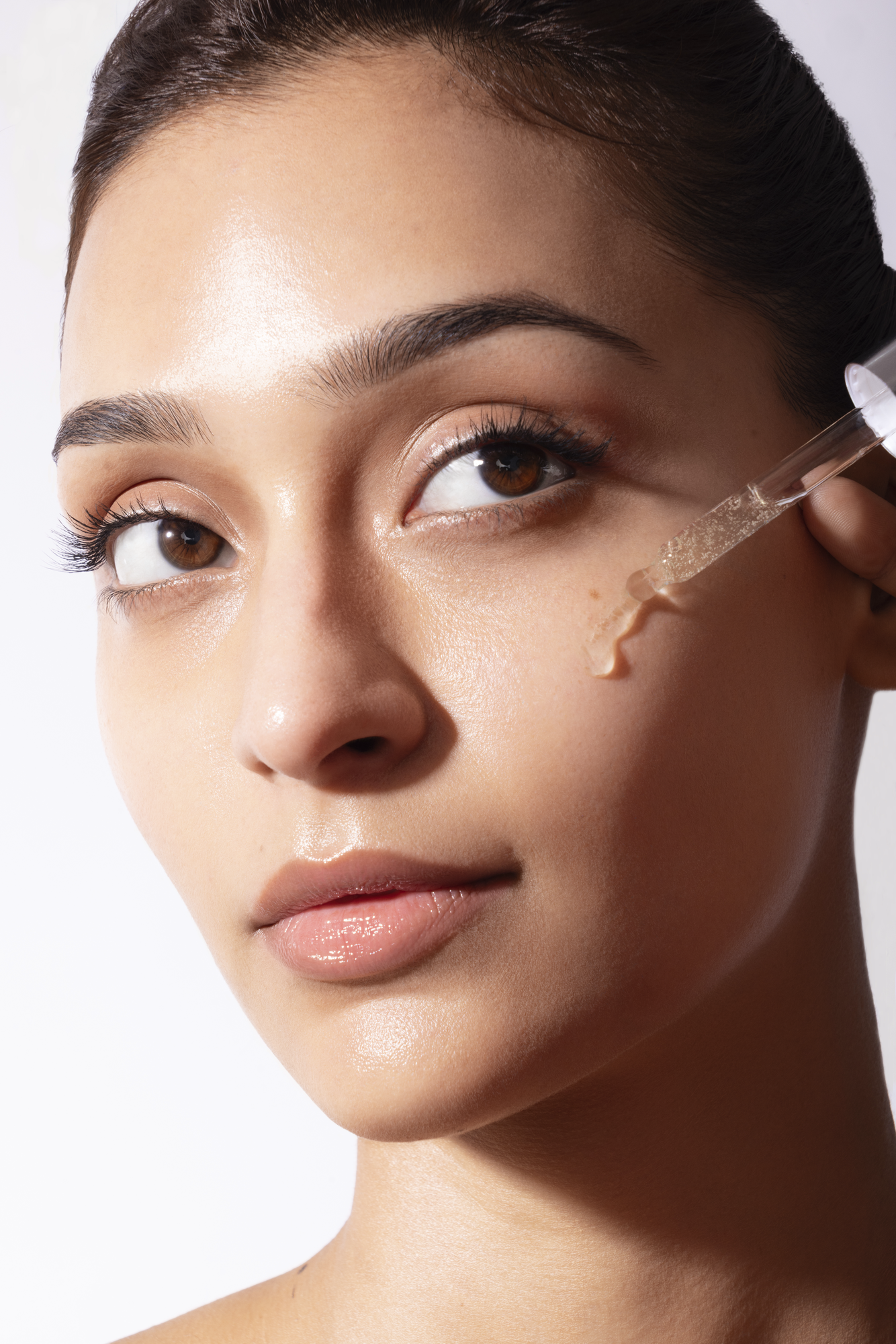 Commercial skincare retouching for cosmetics brand showing liquid serum product application