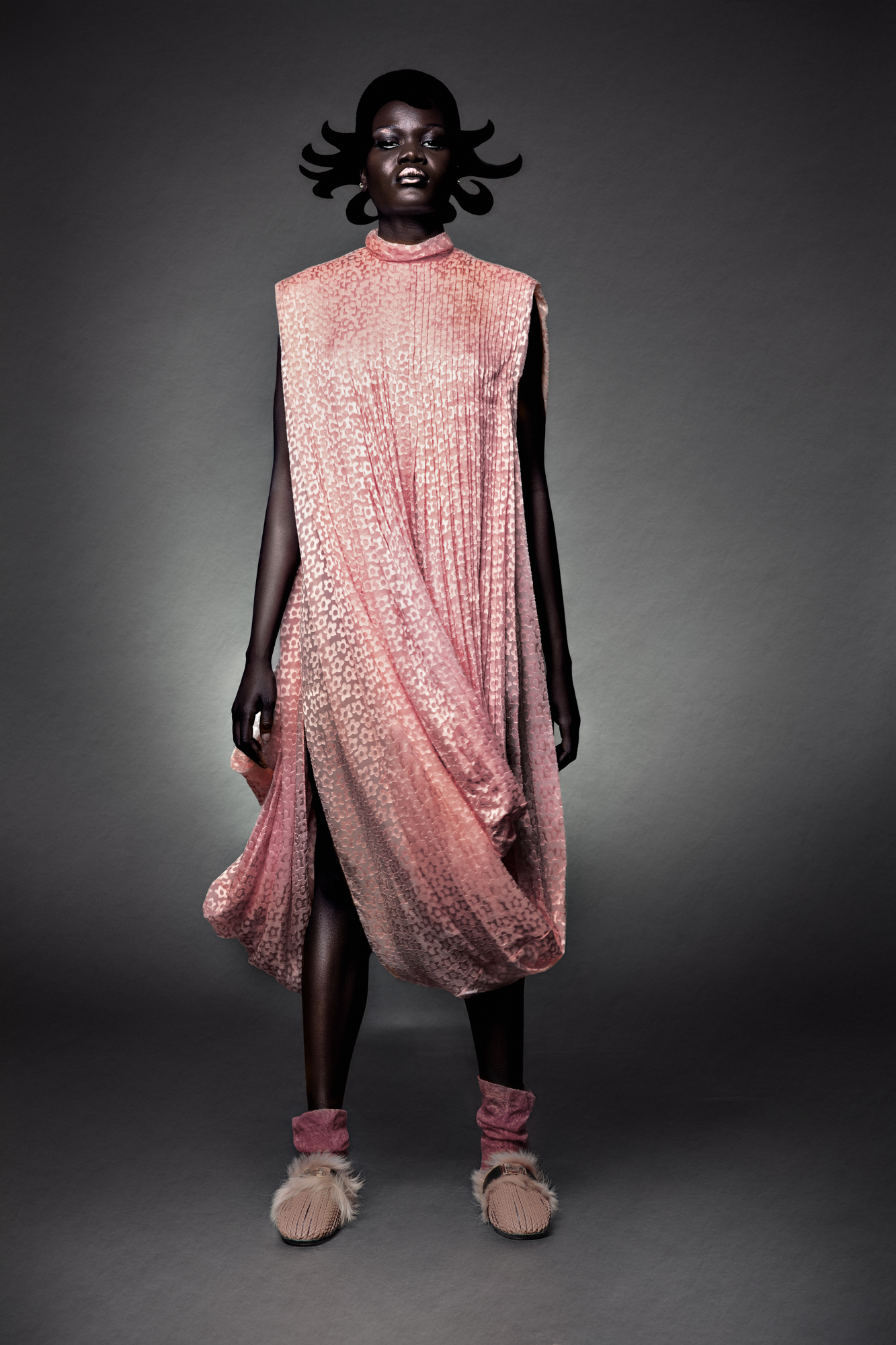 Studio fashion editorial retouching showcasing designer pleated dress texture and professional studio lighting